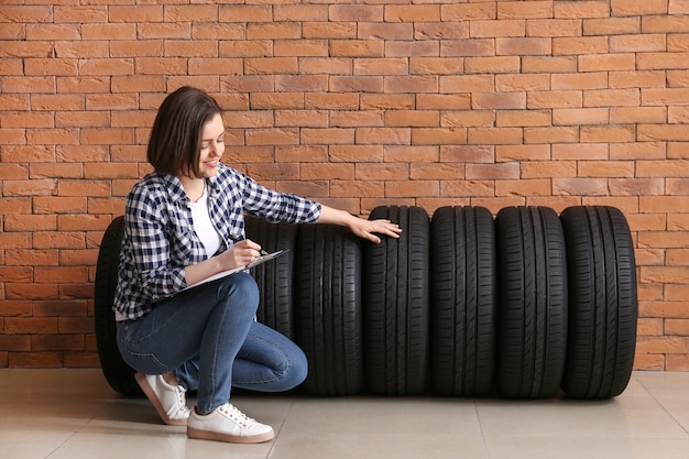 young woman with car tires clipboard near brick wall 392895 11714 1